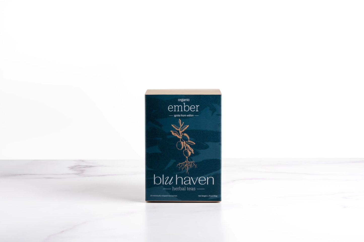 Blu Haven Ember herbal tea box packaging containing sachet tea bags standing on a white marble surface.