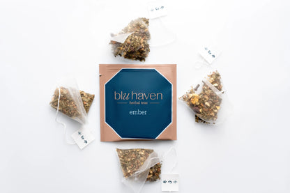 Overhead view of an open Ember tea box displaying individual pyramid sachet tea bags spilling out.