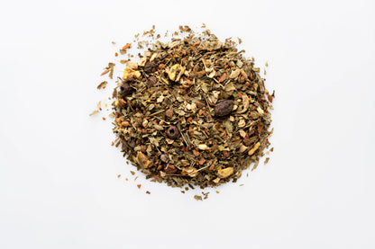 Top down view of a pile of organic loose leaf herbal tea blend showing dried herbs and spices.
